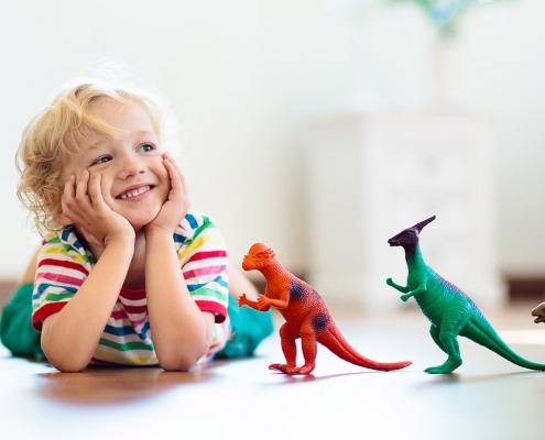 child playing with dinosaur toys
