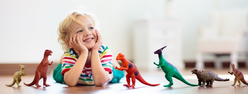 child playing with dinosaur toys